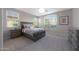 This bedroom is enhanced with natural light, neutral tones, and has calming gray furniture and decor at 20699 W Ridge Rd, Buckeye, AZ 85396