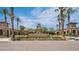 View of the Verrado Golf Club entrance with palm trees, manicured landscaping and building details at 20699 W Ridge Rd, Buckeye, AZ 85396