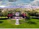 Charming community entrance with lush landscaping, palm trees, and picturesque mountain views at 20699 W Ridge Rd, Buckeye, AZ 85396