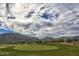 Verrado Golf Course with manicured green and mountain backdrop under a cloudy sky at 20699 W Ridge Rd, Buckeye, AZ 85396