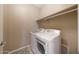 This functional laundry room features modern appliances and space-saving shelf at 20699 W Ridge Rd, Buckeye, AZ 85396