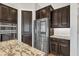 Modern kitchen features stainless steel appliances, dark wood cabinets, and granite countertops at 22218 N 28Th St, Phoenix, AZ 85050