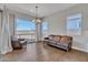 Elegant living room with rich hardwood floors, bright windows, and a classic chandelier at 22218 N 28Th St, Phoenix, AZ 85050