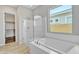 Luxurious main bathroom with a soaking tub, separate shower, and bright window at 22218 N 28Th St, Phoenix, AZ 85050