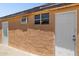 Tan-colored exterior featuring a side entrance door and window, complemented by a concrete slab and textured wall at 2636 N Dayton St, Phoenix, AZ 85006
