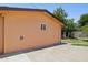 Exterior view of a tan building with a single window, situated on a paved area next to a grassy yard with mature trees at 2636 N Dayton St, Phoenix, AZ 85006