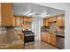 Updated kitchen with wood cabinets, granite counters, stainless steel appliances, and a door to outside at 2636 N Dayton St, Phoenix, AZ 85006