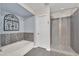 Bathroom featuring a soaking tub, gray tile, and walk-in shower with pebble floor at 308 E Sheffield Ct, Gilbert, AZ 85296
