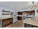 Well-equipped kitchen with stainless steel appliances, granite counters, and dark wood cabinets for a sleek aesthetic at 308 E Sheffield Ct, Gilbert, AZ 85296