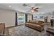 Cozy living room with large area rug and ceiling fan, flowing to the kitchen and views of the outdoor pool at 308 E Sheffield Ct, Gilbert, AZ 85296