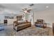 Spacious living room and connected kitchen area with ceiling fan, hardwood floors, and dark wood cabinets at 308 E Sheffield Ct, Gilbert, AZ 85296