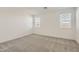 Bright, carpeted bedroom featuring two windows offering ample natural light at 3129 S 155Th Ln, Goodyear, AZ 85338