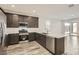 Modern kitchen featuring stainless steel appliances, dark cabinets, quartz countertops, and an open layout at 3129 S 155Th Ln, Goodyear, AZ 85338