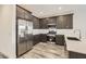 Stylish kitchen featuring stainless steel appliances, dark cabinets, quartz countertops, and wood-look tile floors at 3129 S 155Th Ln, Goodyear, AZ 85338