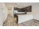 Well-lit open kitchen featuring stainless steel appliances, dark cabinets, quartz countertops, and wood-look tile floors at 3129 S 155Th Ln, Goodyear, AZ 85338