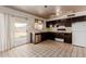 Traditional-style kitchen featuring black cabinetry, standard appliances, with a window and sliding door at 3226 W Grovers Ave, Phoenix, AZ 85053
