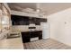 Traditional-style kitchen featuring black cabinetry, standard appliances, and a window above the sink at 3226 W Grovers Ave, Phoenix, AZ 85053