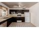 Traditional-style kitchen featuring black cabinetry, standard appliances, and a window above the sink at 3226 W Grovers Ave, Phoenix, AZ 85053