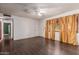 Spacious living room with dark wood laminate flooring, ceiling fan, and natural light at 3226 W Grovers Ave, Phoenix, AZ 85053