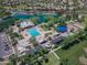 Aerial view of community park featuring a pool, clubhouse, green spaces, playground, and ramadas near a serene lake at 3514 S Posse Trl, Gilbert, AZ 85297