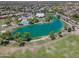 Aerial view of community with lake and recreation area including a pool and walking paths amidst homes and green space at 3514 S Posse Trl, Gilbert, AZ 85297