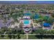 Aerial view of community amenities including a pool, clubhouse, ramadas, playground, and lake in a suburban setting at 3514 S Posse Trl, Gilbert, AZ 85297