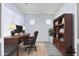 Staged home office features a wood desk, chair, bookcase and decor for a comfortable work environment at 3514 S Posse Trl, Gilbert, AZ 85297