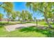 Community sand volleyball court surrounded by green grass and mature trees, perfect for outdoor recreation and fitness at 3514 S Posse Trl, Gilbert, AZ 85297