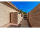 Backyard with covered storage, block wall, and access to a metal fence gate at 371 W Indigo Dr, Chandler, AZ 85248