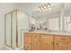 Well-lit bathroom features a framed shower, granite countertops, and a large mirror above the cabinets at 371 W Indigo Dr, Chandler, AZ 85248