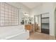 Relaxing bathroom boasts a soaking tub, tiled floors, and a glass-block window for natural light at 371 W Indigo Dr, Chandler, AZ 85248