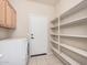 Functional laundry area featuring built-in shelving, storage cabinets and access to the garage at 371 W Indigo Dr, Chandler, AZ 85248