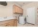 Well-organized laundry room featuring ample cabinet space, a sink, a modern washer, and convenient shelving at 371 W Indigo Dr, Chandler, AZ 85248