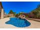 Backyard pool with rock waterfall feature and tropical landscaping, perfect for relaxation and outdoor entertainment at 371 W Indigo Dr, Chandler, AZ 85248