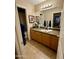 This bathroom features tile flooring, wooden cabinets, granite countertops and a framed mirror at 3891 E Simpson Rd, Gilbert, AZ 85297