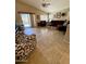Bright living room with tile floors, large windows, and a sliding glass door leading to the backyard at 3891 E Simpson Rd, Gilbert, AZ 85297