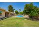 Beautifully landscaped backyard featuring a sparkling pool, lush green lawn, and a covered patio for relaxation at 400 W Crofton St, Chandler, AZ 85225