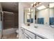 Well-lit bathroom featuring a single sink vanity, framed mirrors, and a shower with glass doors at 400 W Crofton St, Chandler, AZ 85225