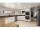 Modern kitchen with white cabinets, granite countertops, stainless steel appliances, and tiled floors at 400 W Crofton St, Chandler, AZ 85225