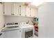 Functional laundry room equipped with appliances, upper cabinets and convenient shelving at 400 W Crofton St, Chandler, AZ 85225