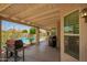 Covered patio with ambient lighting and a barbecue grill, perfect for outdoor dining and entertaining by the pool at 400 W Crofton St, Chandler, AZ 85225