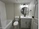 This bathroom features a shower/tub combination with subway tile and a modern vanity with a round mirror at 4425 W Sierra St, Glendale, AZ 85304