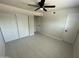 Bright bedroom with tile flooring, a ceiling fan, and a closet with sliding doors at 4425 W Sierra St, Glendale, AZ 85304