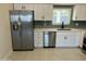 Close up of a kitchen featuring stainless steel appliances, white cabinets, and a gray backsplash at 4425 W Sierra St, Glendale, AZ 85304
