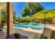 Serene backyard featuring a sparkling pool with rock accents and lush landscaping, ideal for relaxation and entertainment at 4511 E Kirkland Rd, Phoenix, AZ 85050