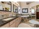 Well-lit bathroom featuring dual sinks, a tiled floor, and a relaxing soaking tub at 4511 E Kirkland Rd, Phoenix, AZ 85050