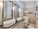Modern bathroom featuring a floating sink, dual mirrors, and a tiled shower at 4511 E Kirkland Rd, Phoenix, AZ 85050