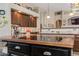 Kitchen features brown cabinets, island with glass cooktop, tile flooring, and view into living room at 4511 E Kirkland Rd, Phoenix, AZ 85050