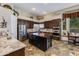 A kitchen with stainless steel appliances, brown cabinets, tile flooring, kitchen island, and dining area at 4511 E Kirkland Rd, Phoenix, AZ 85050