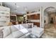 Open living room featuring a kitchen bar area, tile floors, white sofa, and archway to another room at 4511 E Kirkland Rd, Phoenix, AZ 85050